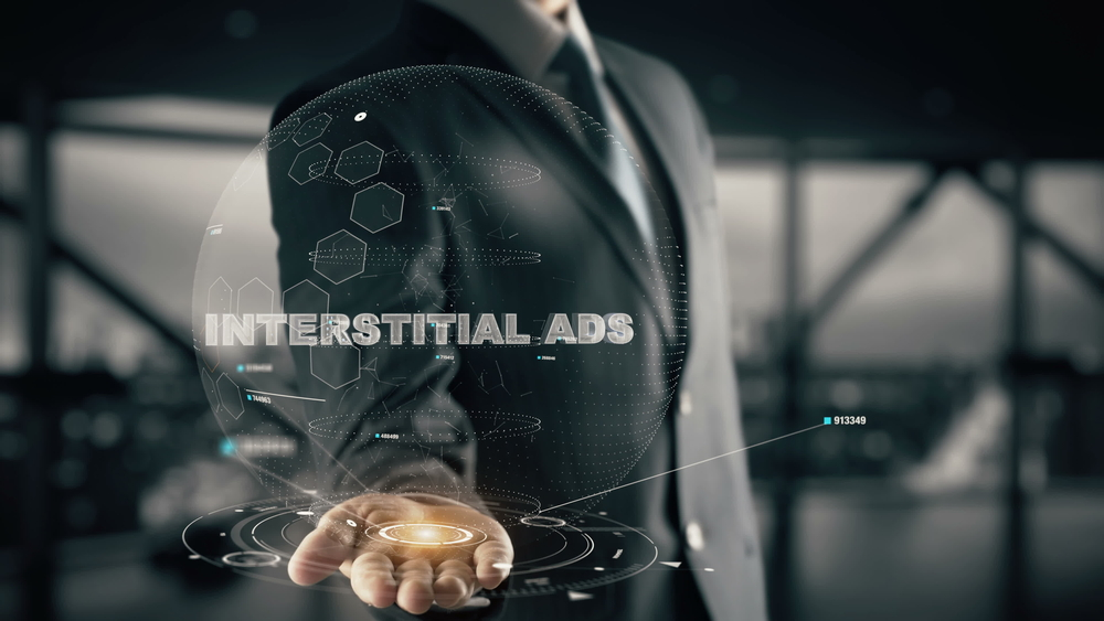 Man in a suit holds his palm out, in his palm is a graphic for Interstitial Ads in a globe shape.